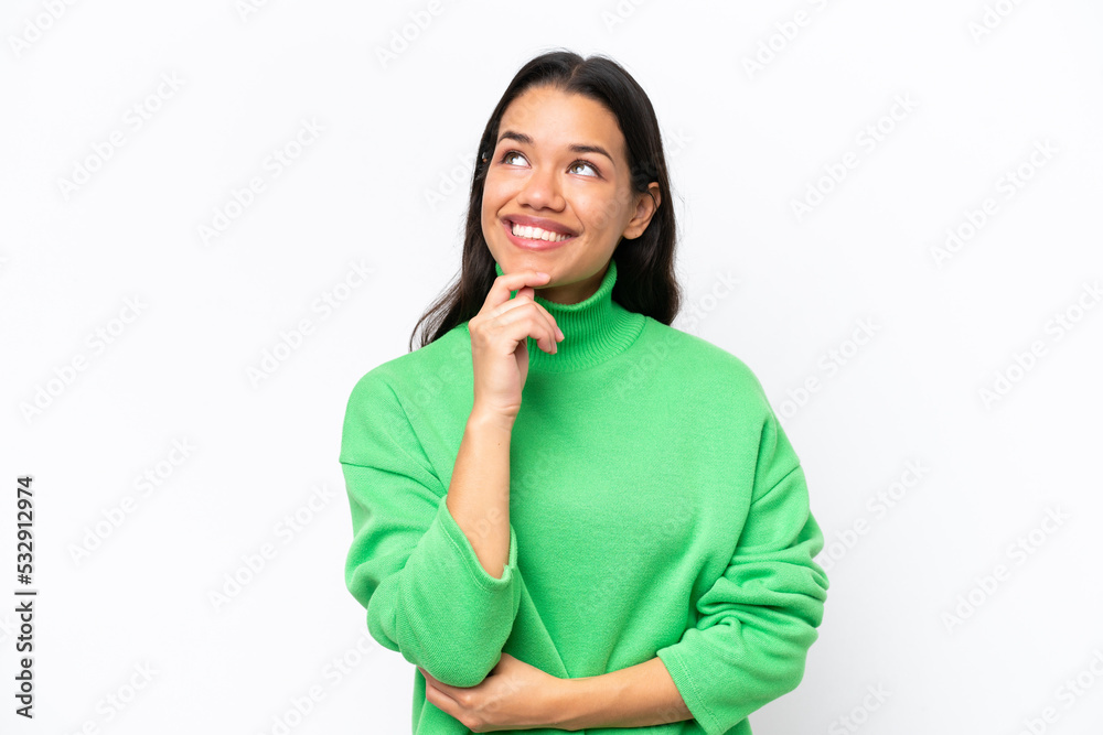 Young Colombian woman isolated on white background and looking up