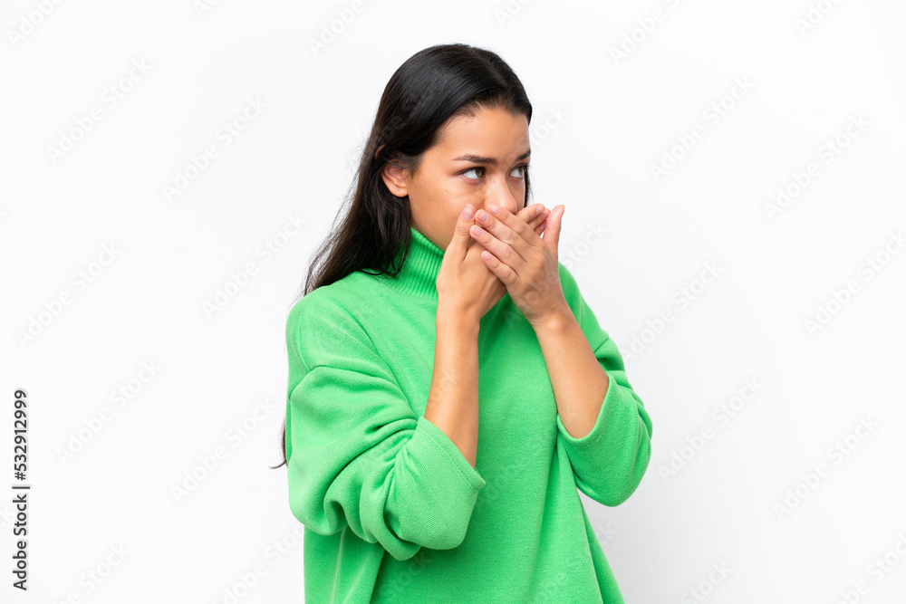 Young Colombian woman isolated on white background covering mouth and looking to the side Young Colombian woman isolated on white background covering mouth and looking to the side