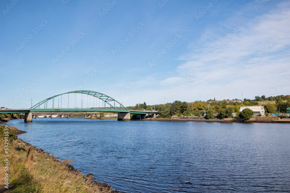 Obraz premium Blaydon England: 17th Sept 2022: View of Newcastle upon Tyne's Scotswood Bridge from the Tyne River in Blaydon. Sunny day with blue sky and light clouds