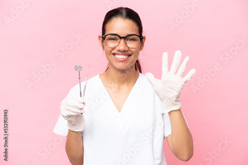 Dentist Colombian woman isolated on pink background counting five with fingers