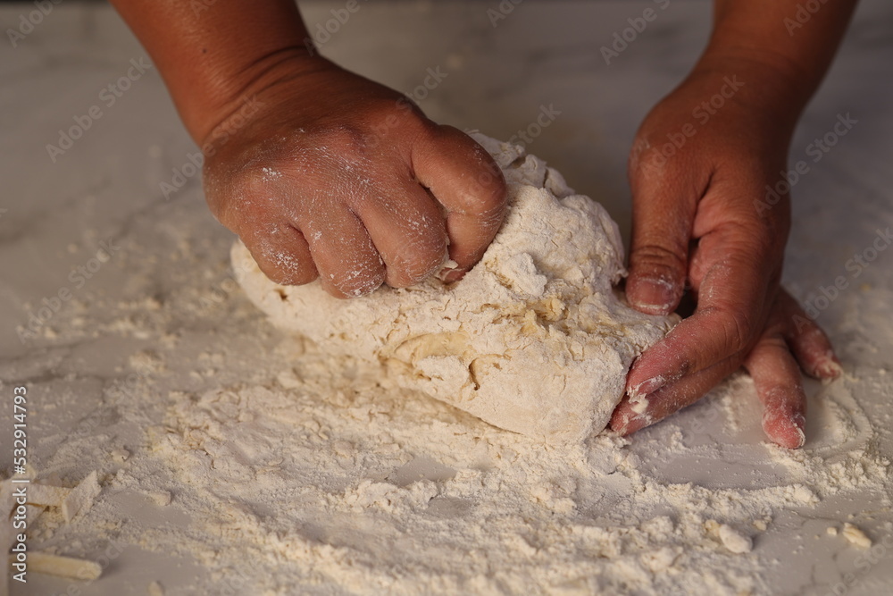 Closeup woman hands kneading fresh dough preparing hammed food on kitchen table, top view  Food background, copy space.