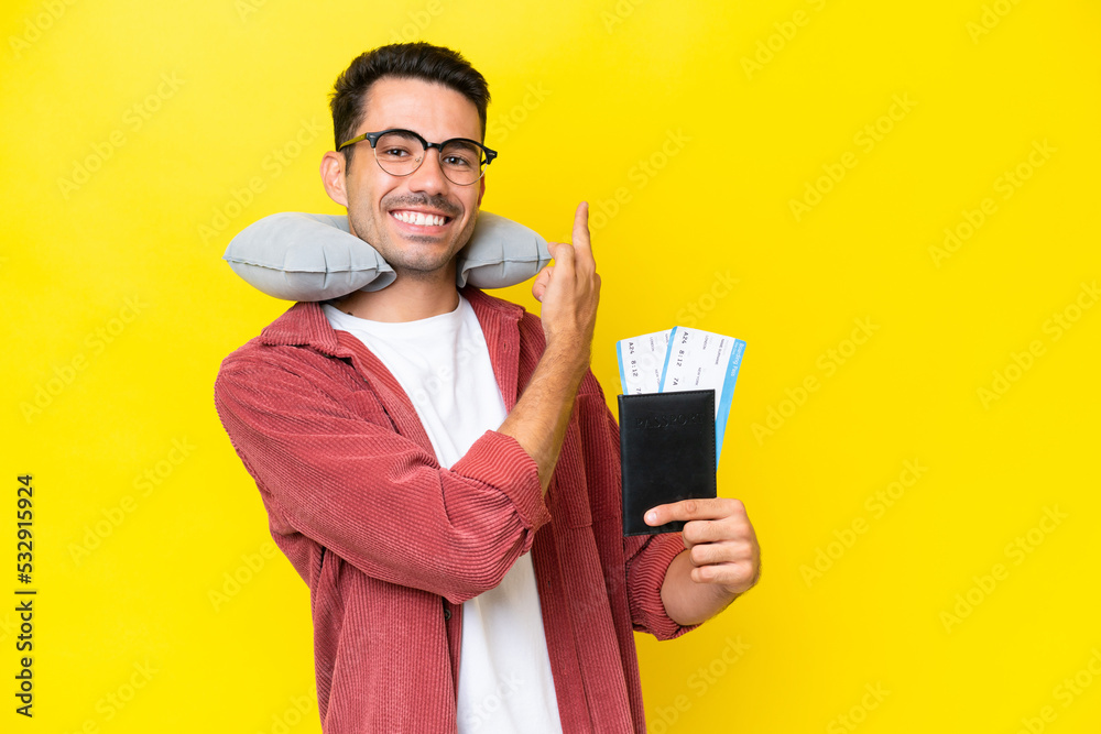 Young handsome man with Inflatable Travel Pillow over isolated yellow background pointing back Young handsome man with Inflatable Travel Pillow over isolated yellow background pointing back