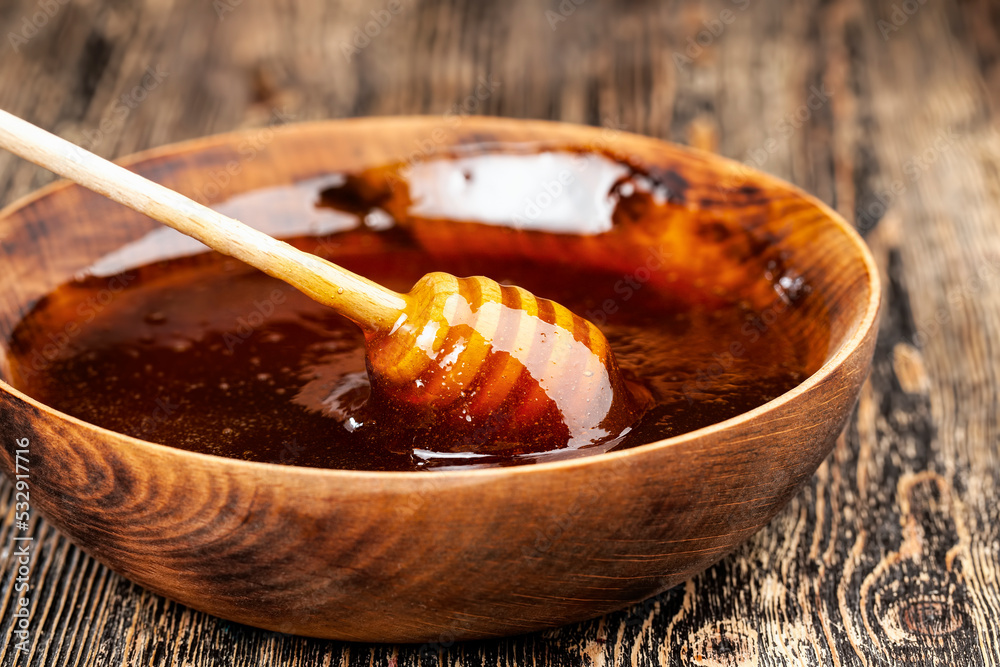 Fototapeta premium Sweet bee honey in a transparent glass jar