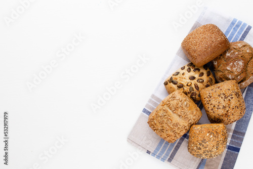 Gold rustic crusty loaves of bread and buns on wooden background. Still life captured from above top view, flat lay.