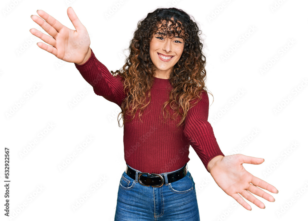 Young hispanic girl wearing casual clothes looking at the camera smiling with open arms for hug. cheerful expression embracing happiness. Young hispanic girl wearing casual clothes looking at the camera smiling with open arms for hug. cheerful expression embracing happiness.