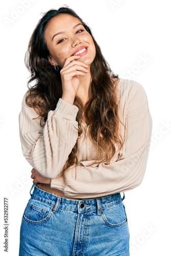 Young hispanic girl wearing casual clothes smiling looking confident at the camera with crossed arms and hand on chin. thinking positive.
