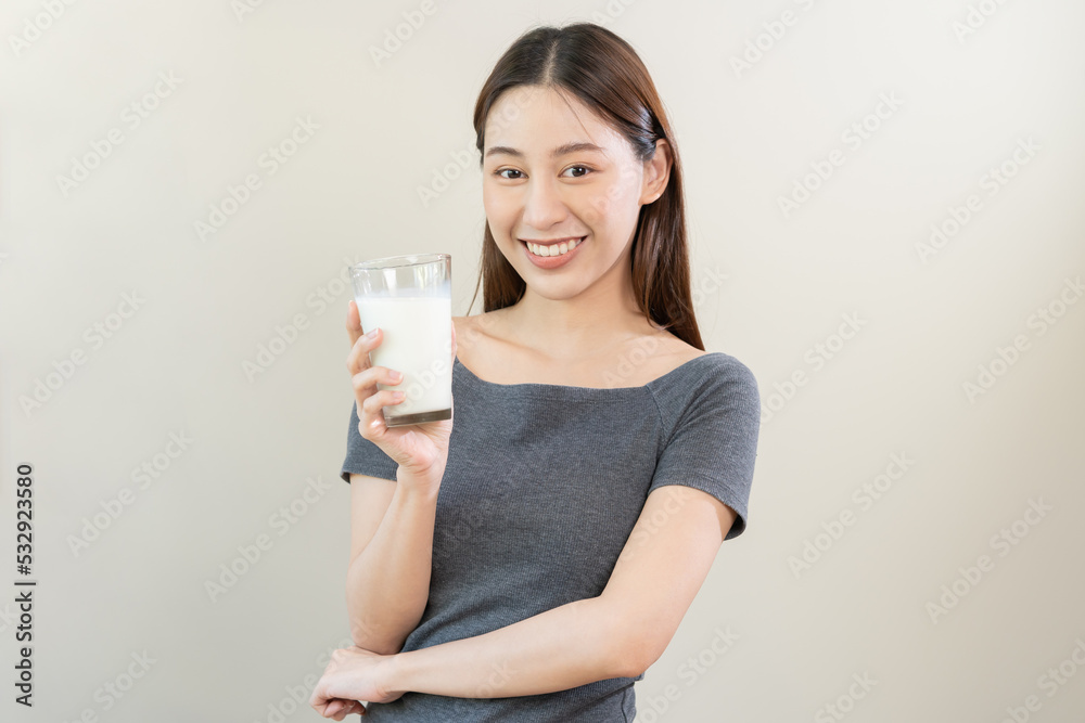 Happy, asian young woman, girl drinking a glass of white fresh, warm or hot dairy milk for calcium, vitamin wholesome good nutrition in morning. lifestyle, product healthy people, Isolated background. Happy, asian young woman, girl drinking a glass of white fresh, warm or hot dairy milk for calcium, vitamin wholesome good nutrition in morning. lifestyle, product healthy people, Isolated background.