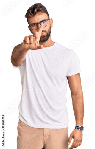 Young hispanic man wearing casual clothes and glasses pointing with finger up and angry expression, showing no gesture