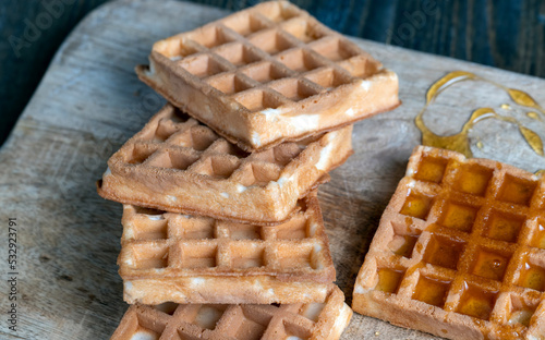 square sweet soft waffles in bee honey photo