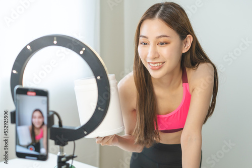 Vlogger asian young woman blogger, influencer showing product of health care, using smart mobile phone live selling food replacement, weight lose. Show goods to customer, present, streaming online.