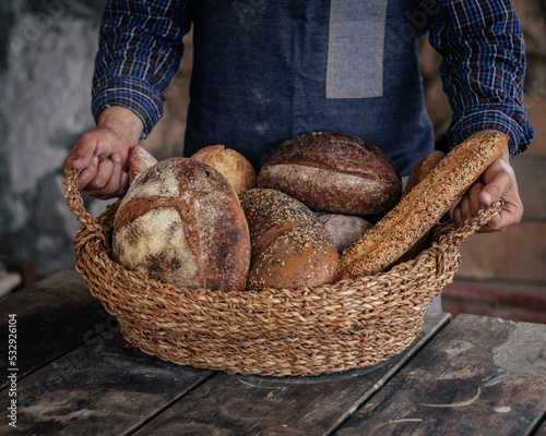 Cesta con variedad de pan sostenida por manos.