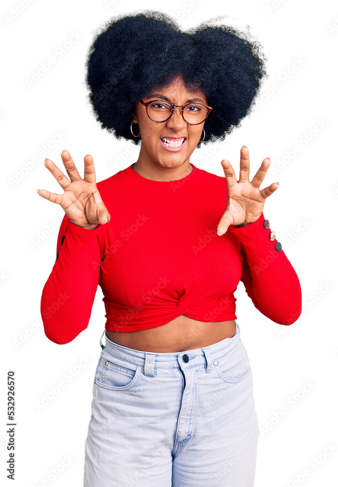 Young african american girl wearing casual clothes and glasses smiling funny doing claw gesture as cat, aggressive and sexy expression Young african american girl wearing casual clothes and glasses smiling funny doing claw gesture as cat, aggressive and sexy expression