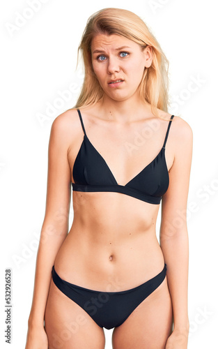 Young beautiful blonde woman wearing bikini skeptic and nervous, frowning upset because of problem. negative person.