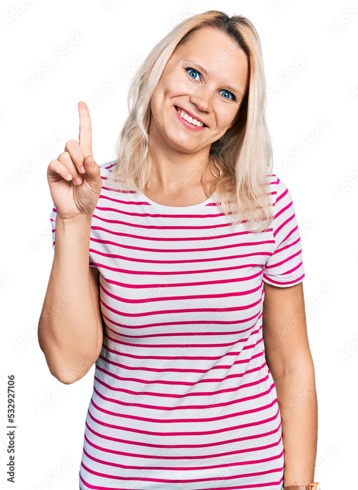 Young caucasian woman wearing casual clothes showing and pointing up with finger number one while smiling confident and happy. Young caucasian woman wearing casual clothes showing and pointing up with finger number one while smiling confident and happy.