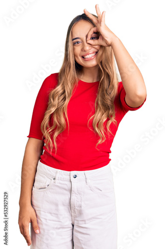 Young beautiful blonde woman wearing casual clothes doing ok gesture with hand smiling, eye looking through fingers with happy face. photo