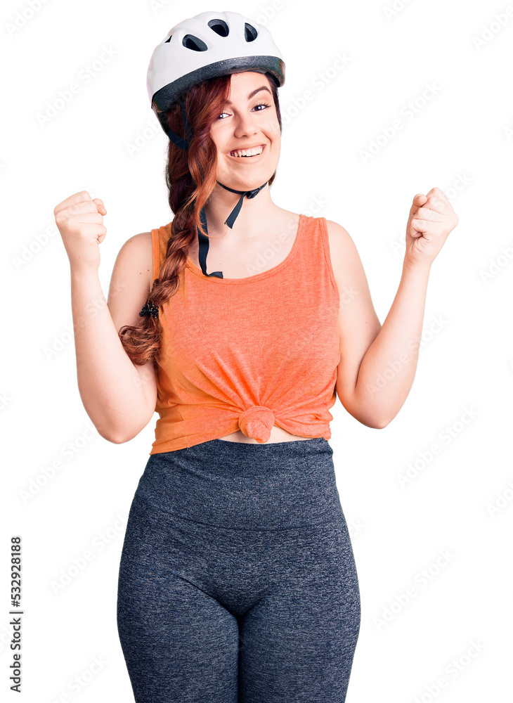 Young beautiful woman wearing bike helmet screaming proud, celebrating victory and success very excited with raised arms