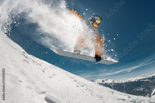 Professional snowboarder jump at off-piste ski slope. Extreme sports concept