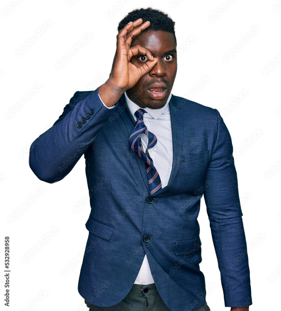 Handsome business black man wearing business suit and tie doing ok gesture shocked with surprised face, eye looking through fingers. unbelieving expression. Handsome business black man wearing business suit and tie doing ok gesture shocked with surprised face, eye looking through fingers. unbelieving expression.