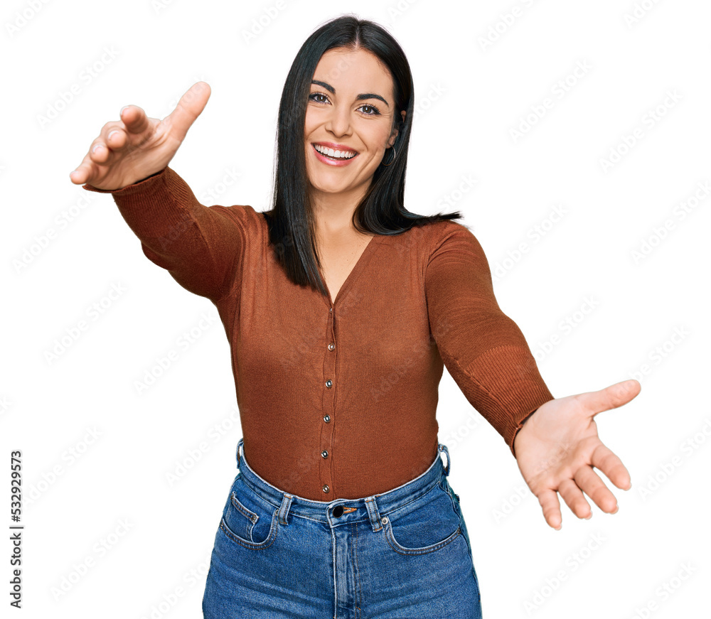 Young hispanic woman wearing casual clothes looking at the camera smiling with open arms for hug. cheerful expression embracing happiness. Young hispanic woman wearing casual clothes looking at the camera smiling with open arms for hug. cheerful expression embracing happiness.