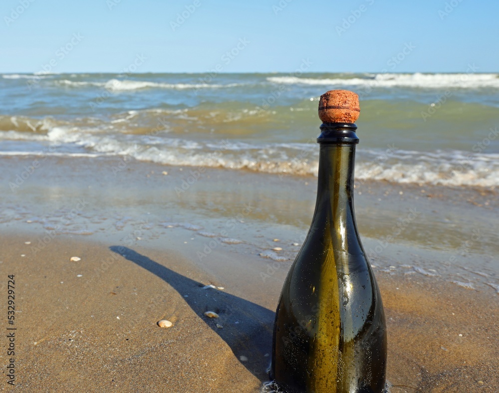 beached green glass bottle with a message inside on the foreshore beached green glass bottle with a message inside on the foreshore