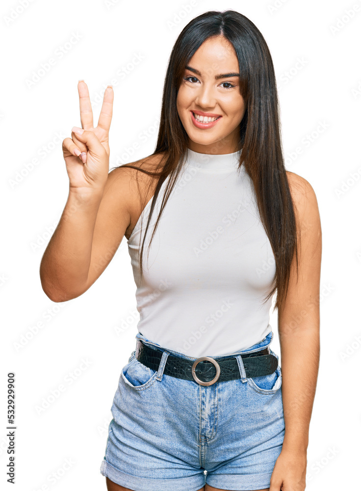 Young beautiful hispanic girl wearing casual clothes showing and pointing up with fingers number two while smiling confident and happy. Young beautiful hispanic girl wearing casual clothes showing and pointing up with fingers number two while smiling confident and happy.