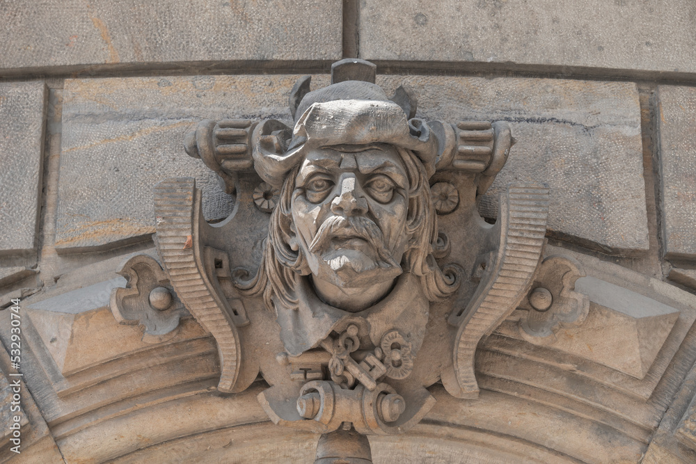 Ancient sculpture of scary, fearful and heavy armed gatekeeper, medieval warrior with weapon in historical downtown of Dresden, Germany, details, closeup. Authentic European old architecture.