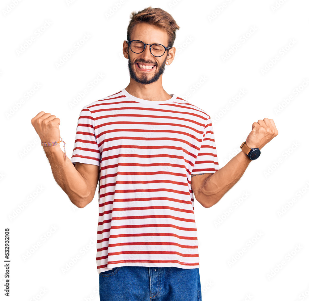 Handsome blond man with beard wearing casual clothes and glasses very happy and excited doing winner gesture with arms raised, smiling and screaming for success. celebration concept. Handsome blond man with beard wearing casual clothes and glasses very happy and excited doing winner gesture with arms raised, smiling and screaming for success. celebration concept.