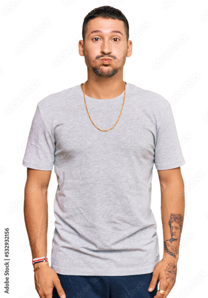 Handsome man with tattoos wearing 90s style puffing cheeks with funny face. mouth inflated with air, crazy expression. Handsome man with tattoos wearing 90s style puffing cheeks with funny face. mouth inflated with air, crazy expression.