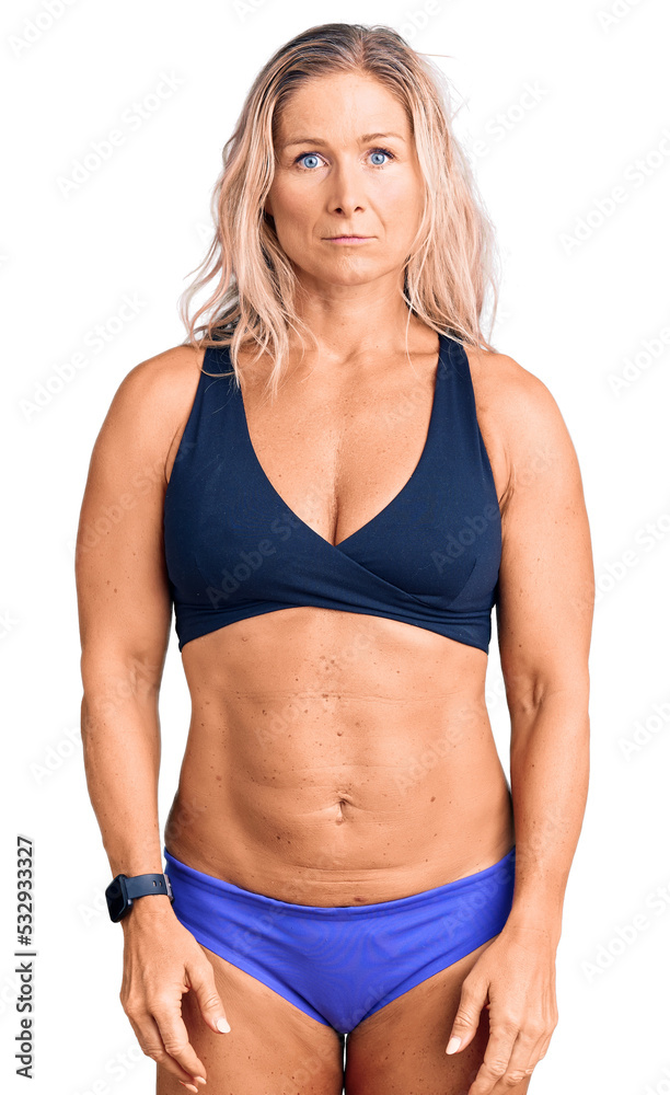 Middle age fit blonde woman wearing bikini depressed and worry for distress, crying angry and afraid. sad expression. Middle age fit blonde woman wearing bikini depressed and worry for distress, crying angry and afraid. sad expression.