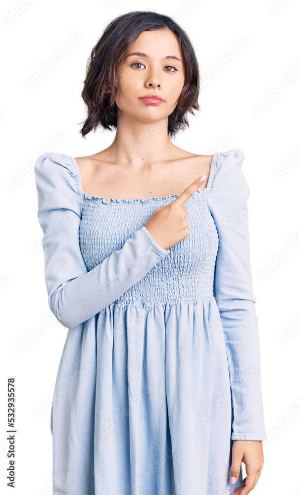 Young beautiful girl wearing casual clothes pointing with hand finger to the side showing advertisement, serious and calm face Young beautiful girl wearing casual clothes pointing with hand finger to the side showing advertisement, serious and calm face