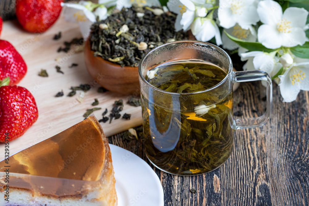 Fototapeta premium Brewed green tea with jasmine on the table