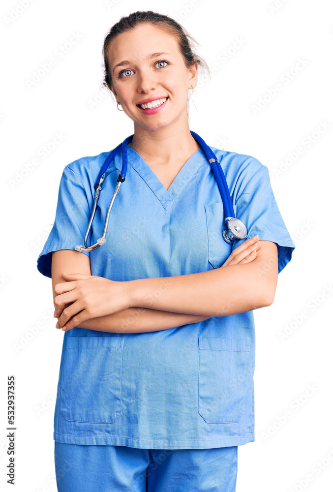Young beautiful blonde woman wearing doctor uniform and stethoscope happy face smiling with crossed arms looking at the camera. positive person. Young beautiful blonde woman wearing doctor uniform and stethoscope happy face smiling with crossed arms looking at the camera. positive person.