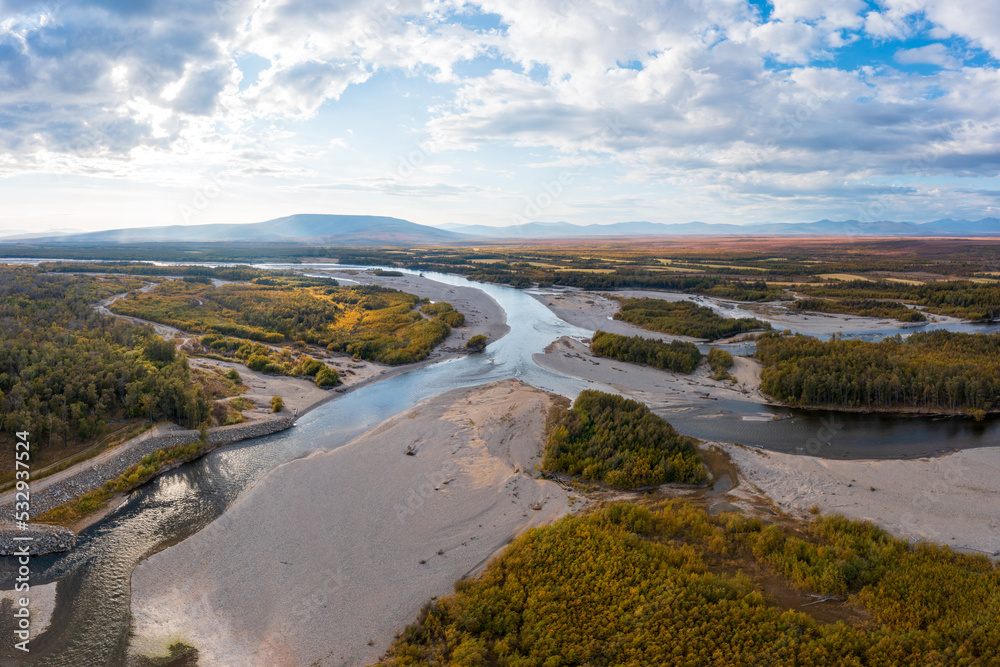 Obraz premium Aerial view of the river. Top view of the plain, river and forest. Mountains in the distance. Autumn season. September. Beautiful nature of Siberia. Ola River, Magadan Region, Russian Far East.