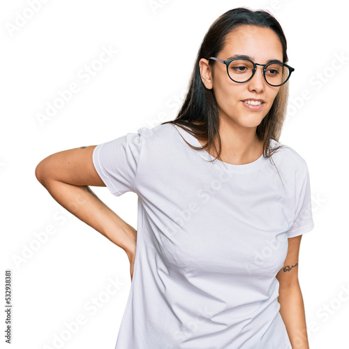 Young hispanic woman wearing casual white t shirt suffering of backache, touching back with hand, muscular pain © Krakenimages.com