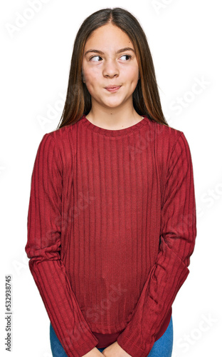 Beautiful brunette little girl wearing casual sweater smiling looking to the side and staring away thinking. © Krakenimages.com