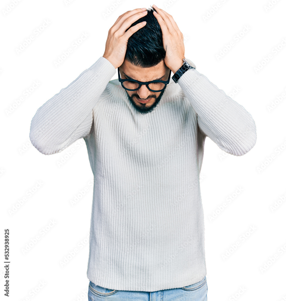 Young arab man with beard wearing elegant turtleneck sweater and glasses suffering from headache desperate and stressed because pain and migraine. hands on head. Young arab man with beard wearing elegant turtleneck sweater and glasses suffering from headache desperate and stressed because pain and migraine. hands on head.
