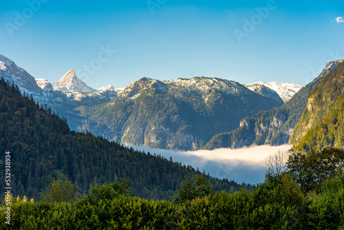 View to the Königssee covered with clouds. In the background the Steinerne Meer with the characteristic Schönfeldspitze 2653m above sea level. The Rocky Sea is a sub-range of the Berchtesgaden Alps