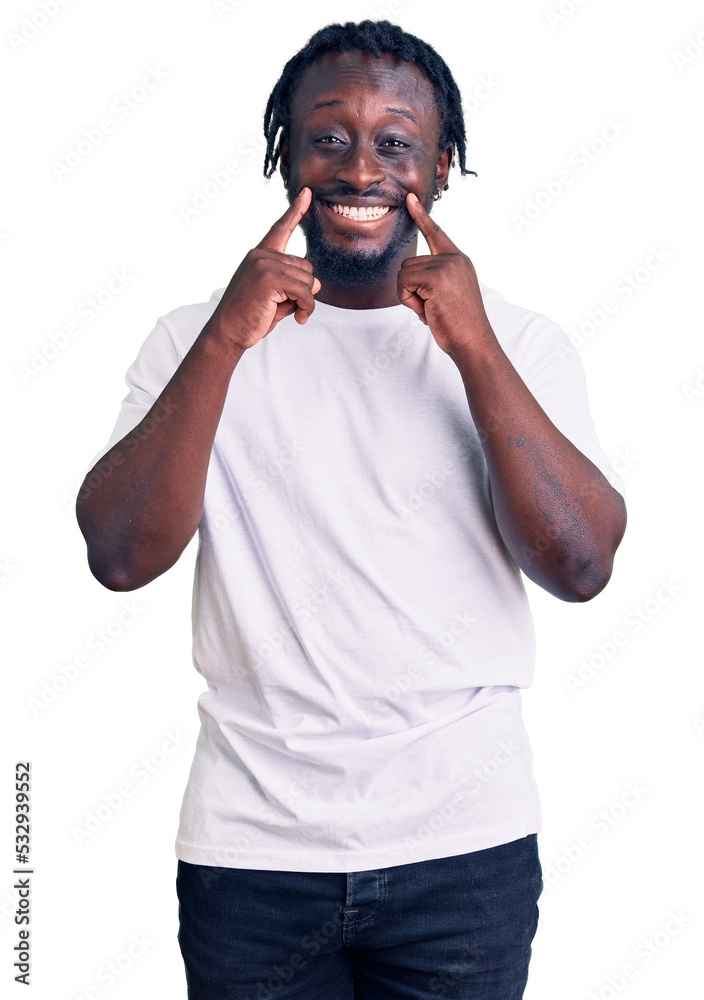 Young african american man with braids wearing casual white tshirt smiling with open mouth, fingers pointing and forcing cheerful smile Young african american man with braids wearing casual white tshirt smiling with open mouth, fingers pointing and forcing cheerful smile