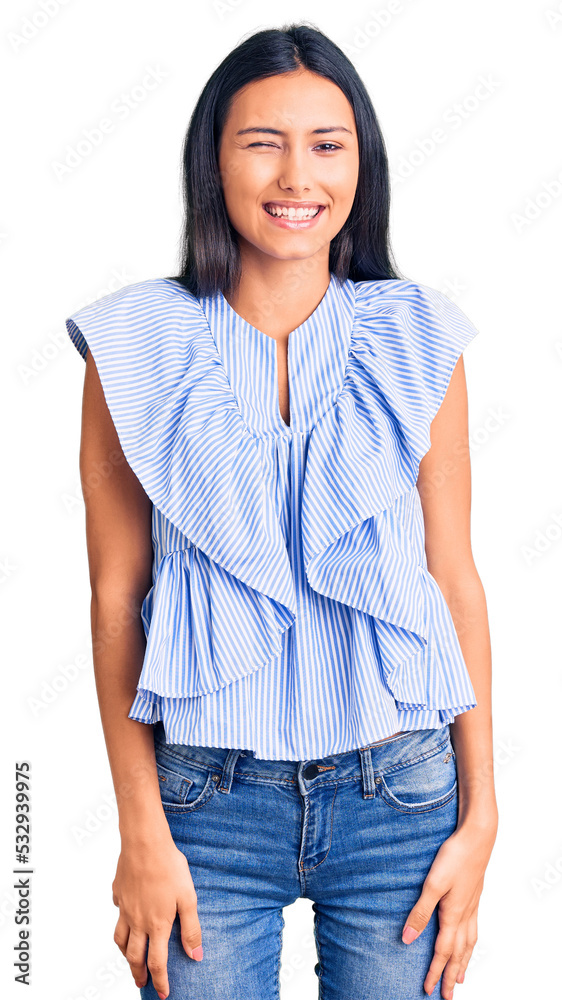 Young beautiful latin girl wearing casual clothes winking looking at the camera with sexy expression, cheerful and happy face. Young beautiful latin girl wearing casual clothes winking looking at the camera with sexy expression, cheerful and happy face.