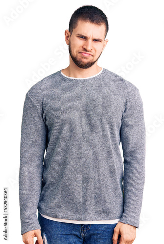 Young handsome man wearing casual sweater skeptic and nervous, frowning upset because of problem. negative person.