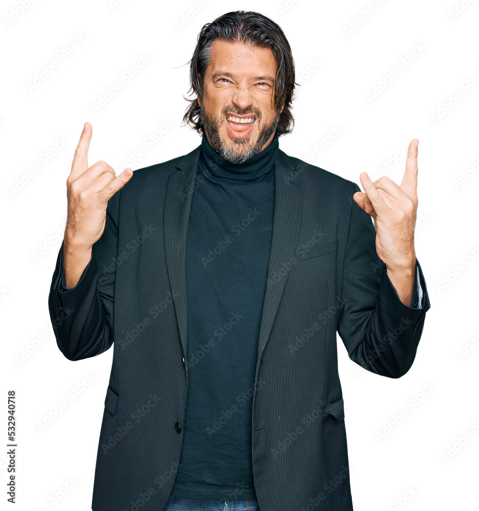 Middle age handsome man wearing business clothes shouting with crazy expression doing rock symbol with hands up. music star. heavy concept. Middle age handsome man wearing business clothes shouting with crazy expression doing rock symbol with hands up. music star. heavy concept.