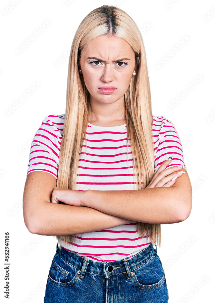 Beautiful blonde woman wearing casual striped t shirt skeptic and nervous, disapproving expression on face with crossed arms. negative person.