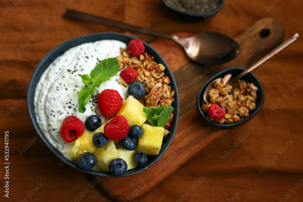 Healthy breakfast bowl with chia yogurt, crunches and fruits.
