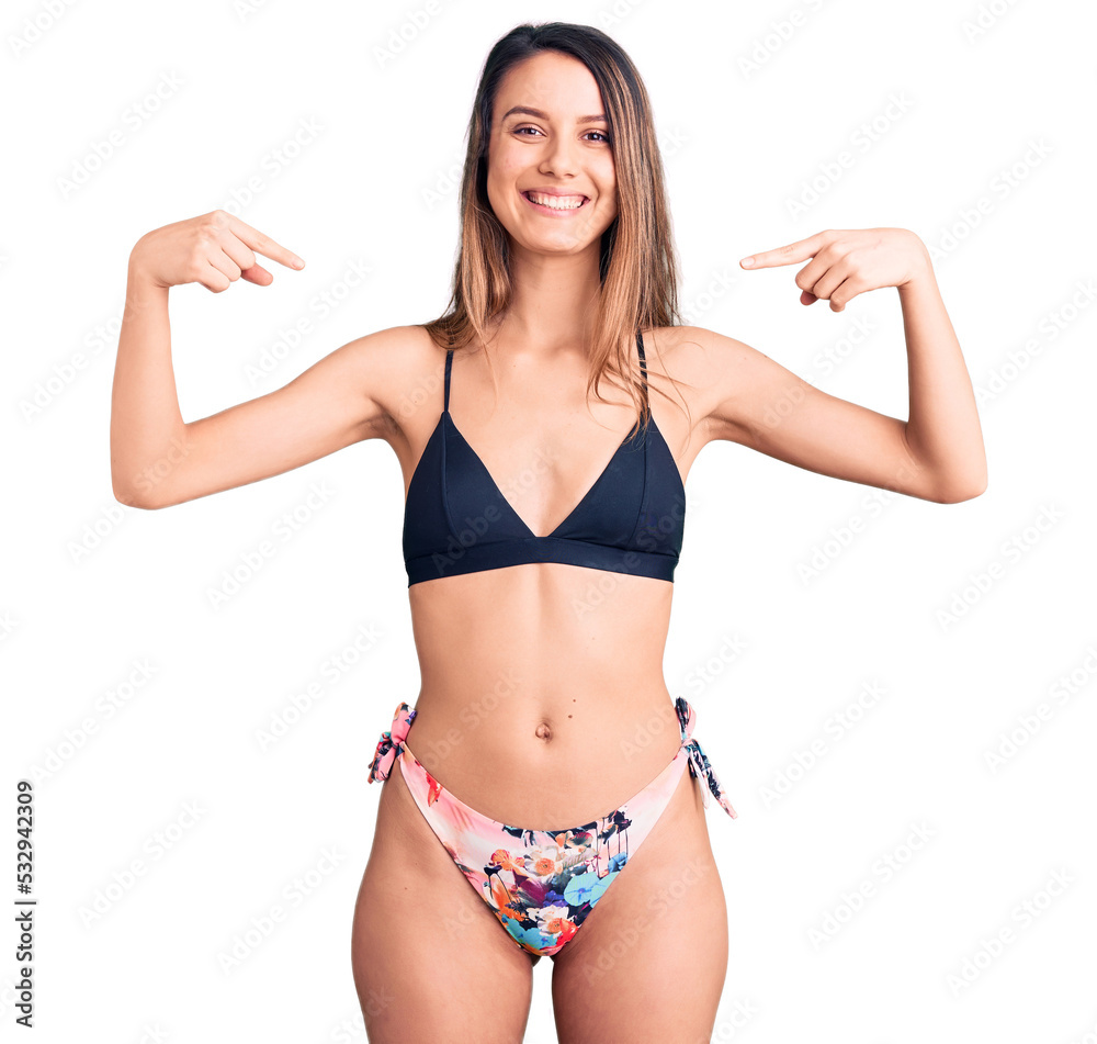 Young beautiful girl wearing bikini looking confident with smile on face, pointing oneself with fingers proud and happy. Young beautiful girl wearing bikini looking confident with smile on face, pointing oneself with fingers proud and happy.