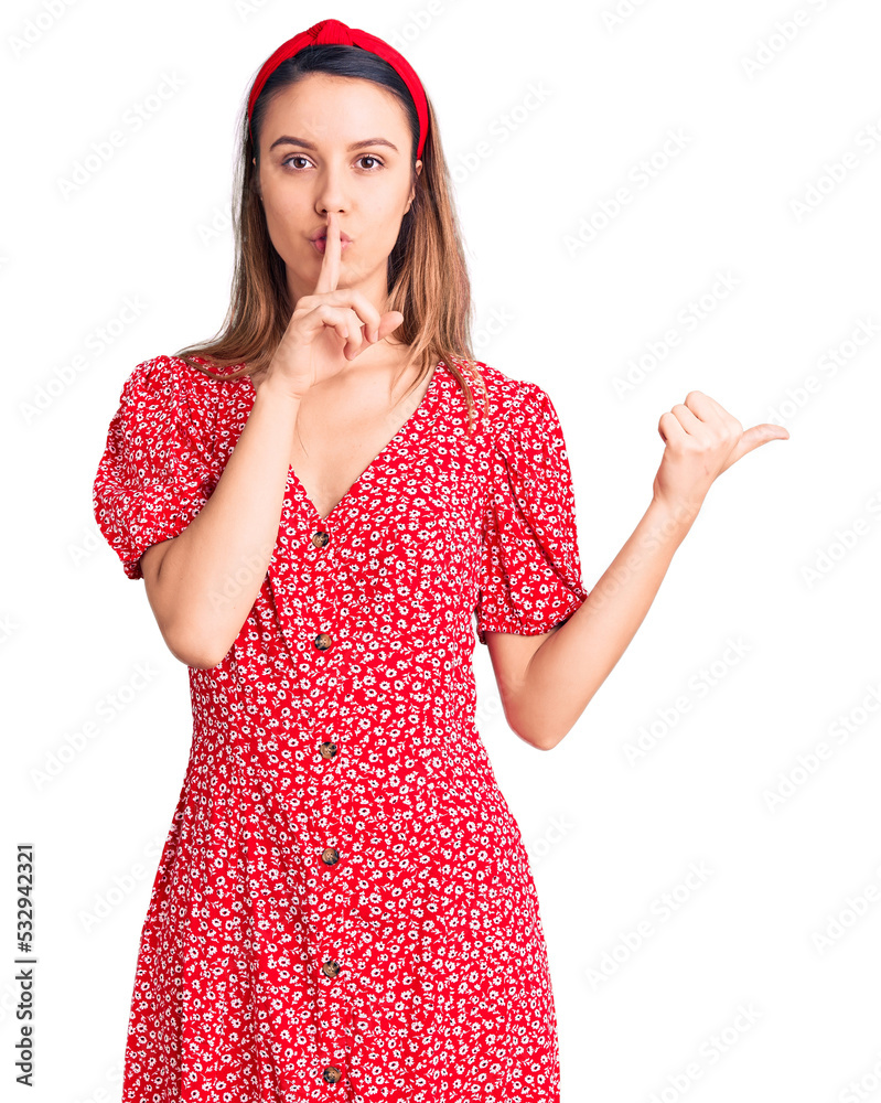 Young beautiful girl wearing dress and diadem asking to be quiet with finger on lips pointing with hand to the side. silence and secret concept. Young beautiful girl wearing dress and diadem asking to be quiet with finger on lips pointing with hand to the side. silence and secret concept.