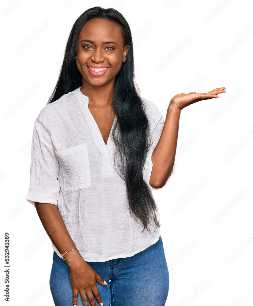 Young black woman wearing casual clothes smiling cheerful presenting and pointing with palm of hand looking at the camera. Young black woman wearing casual clothes smiling cheerful presenting and pointing with palm of hand looking at the camera.
