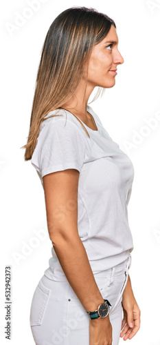 Young woman wearing casual white t shirt looking to side, relax profile pose with natural face with confident smile.