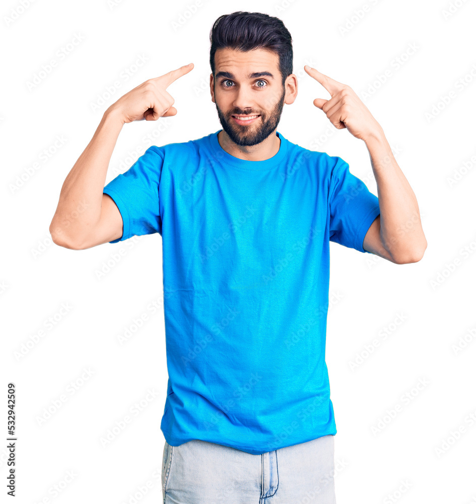 Young handsome man with beard wearing casual t-shirt smiling pointing to head with both hands finger, great idea or thought, good memory Young handsome man with beard wearing casual t-shirt smiling pointing to head with both hands finger, great idea or thought, good memory