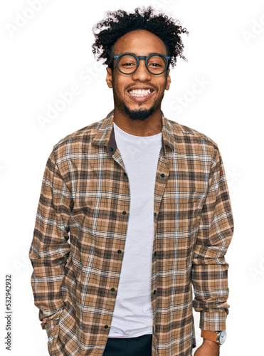 Young african american man with beard wearing casual clothes and glasses with a happy and cool smile on face. lucky person.