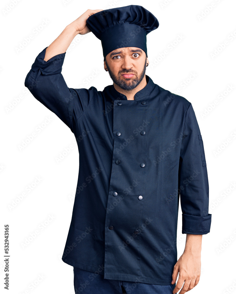 Young hispanic man wearing cooker uniform confuse and wonder about question. uncertain with doubt, thinking with hand on head. pensive concept. Young hispanic man wearing cooker uniform confuse and wonder about question. uncertain with doubt, thinking with hand on head. pensive concept.